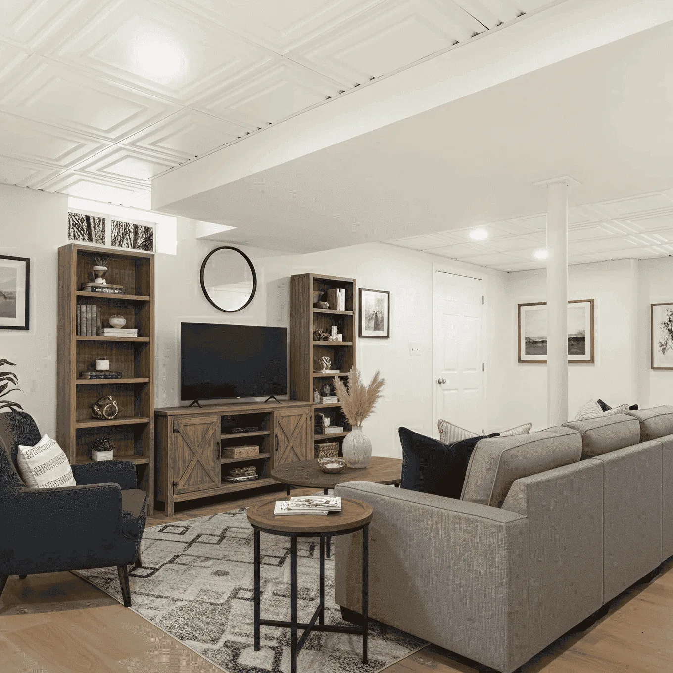 Finished basement renovation in Westchester, NY featuring cozy lounge with sectional sofa, built-in bookshelves, and entertainment area.