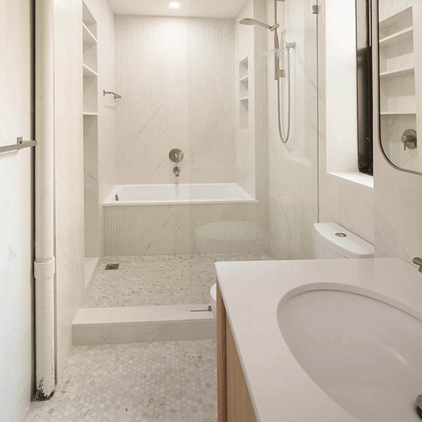 Bright renovated bathroom with a walk-in shower, built-in bathtub, and penny tile flooring