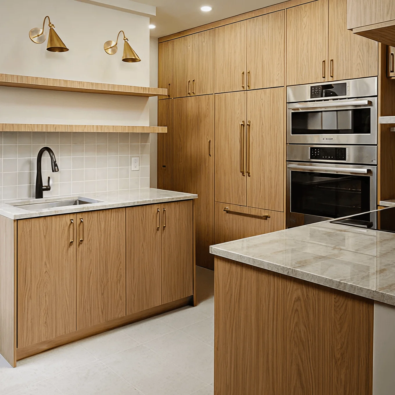 Renovated kitchen with light wood cabinetry, built-in wall ovens, and marble countertops