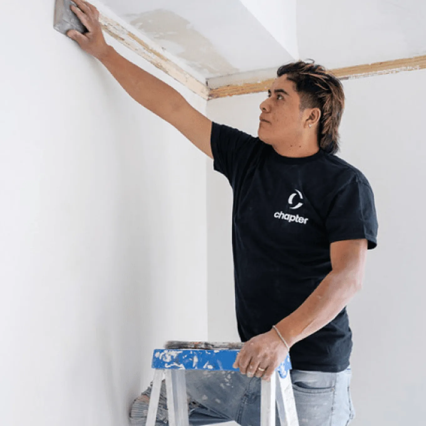 Renovation crew installing fixtures and inspecting progress in an open-concept living area with tools visible