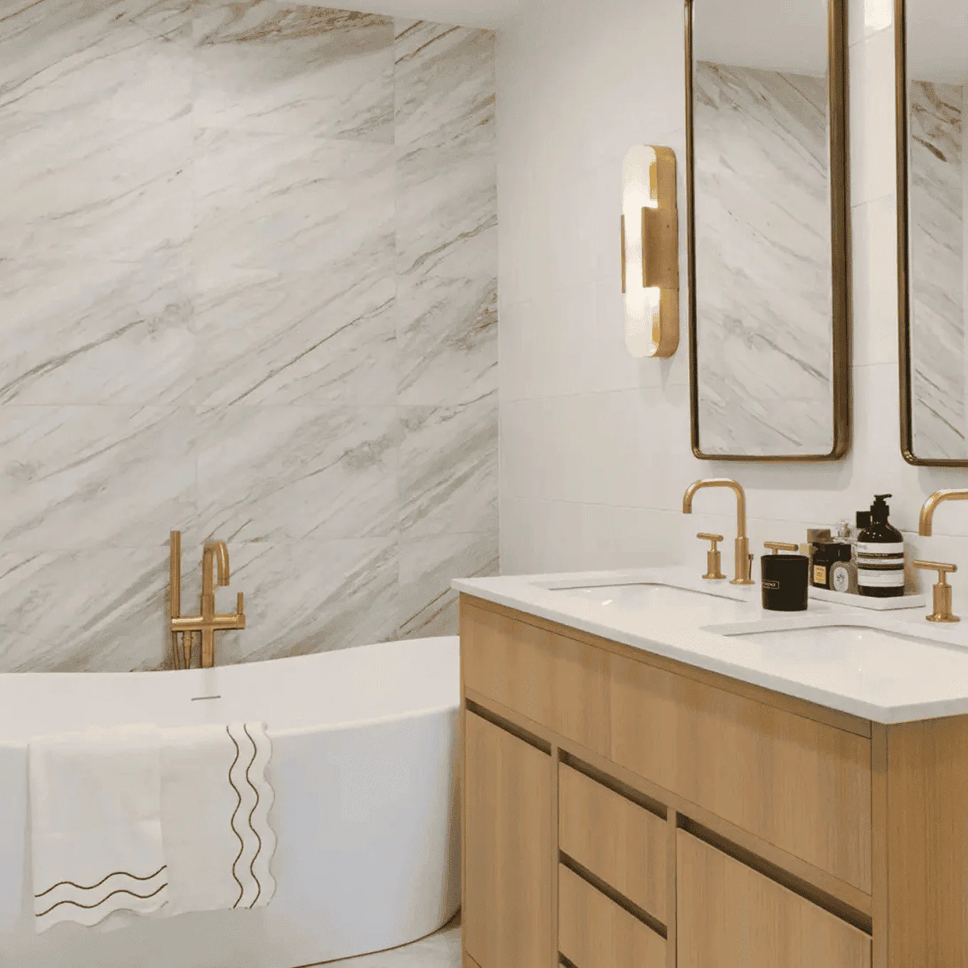 Luxury bathroom renovation in Tribeca, NYC with marble walls, soaking tub, and custom vanity.