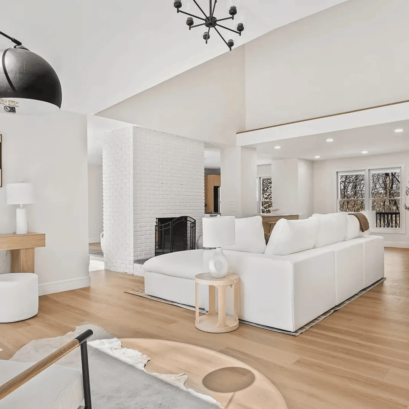 Stairs landing with wood flooring, wooden railing, and a modern chandelier in Connecticut.
