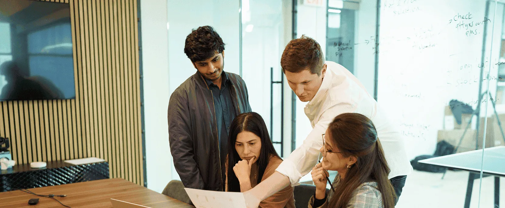 Chapter project team meeting with designers and project managers reviewing renovation plans in a modern conference room during project setup phase.