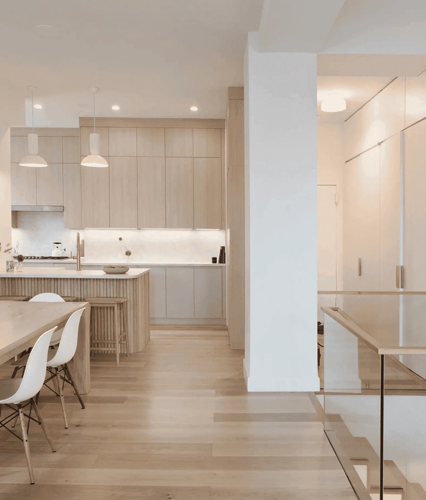 Modern duplex apartment kitchen renovation in Tribeca, New York City, featuring light wood cabinetry, minimalist island, and open dining area. design-build project by Chapter.