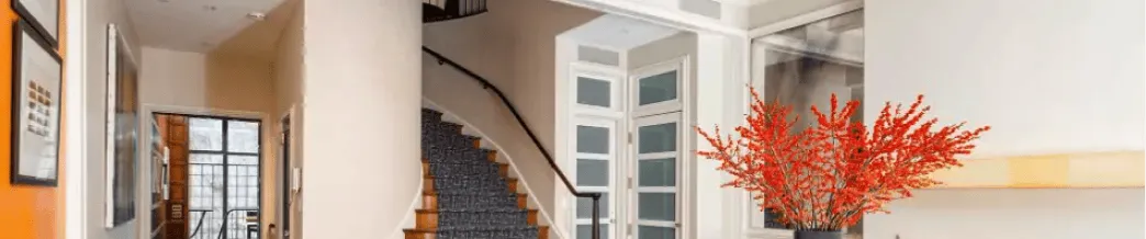 Renovated NYC townhouse interior with modern staircase, bright hallway, and architectural details — structural and exterior work by Chapter.