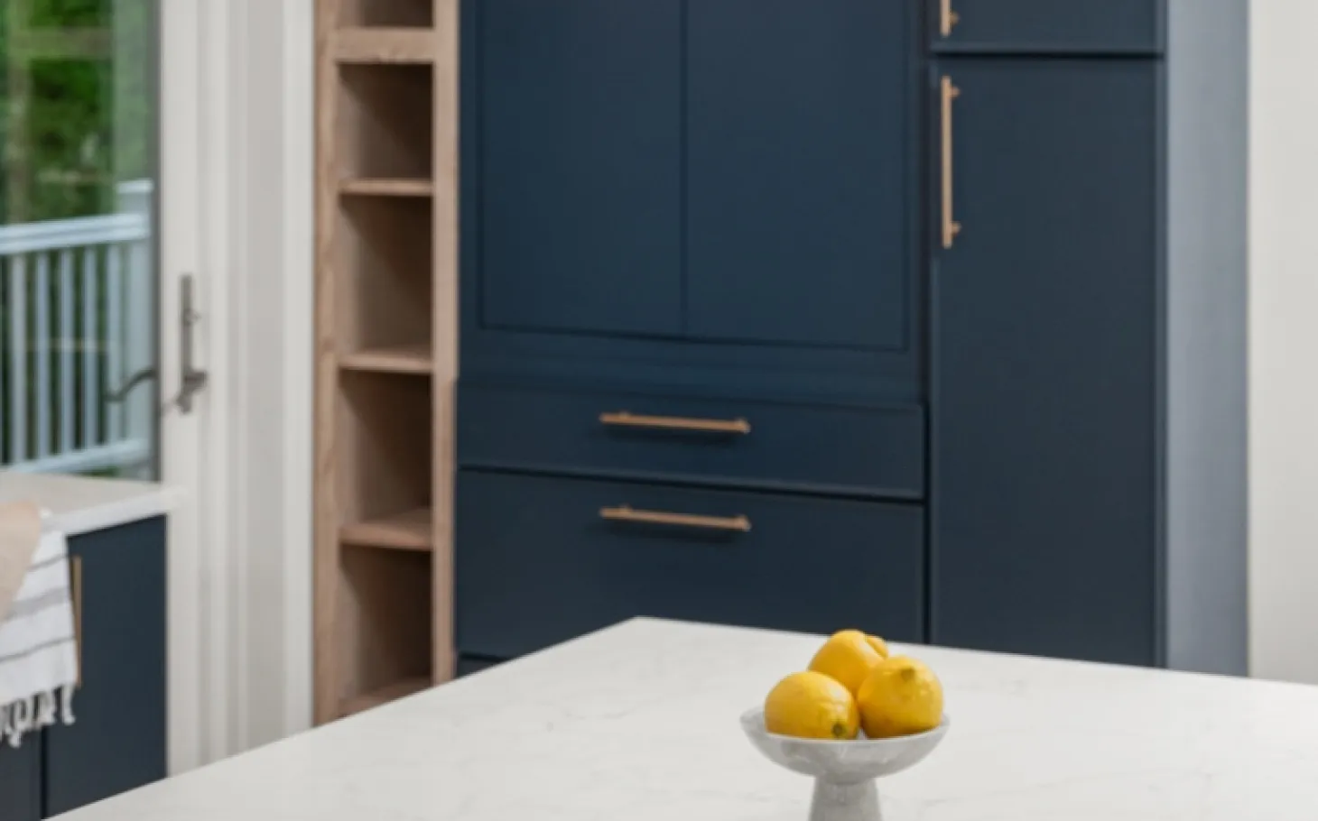 Design overview of Rye home featuring deep blue kitchen cabinetry, white oak accents, quartz island, and spa-inspired primary bathroom