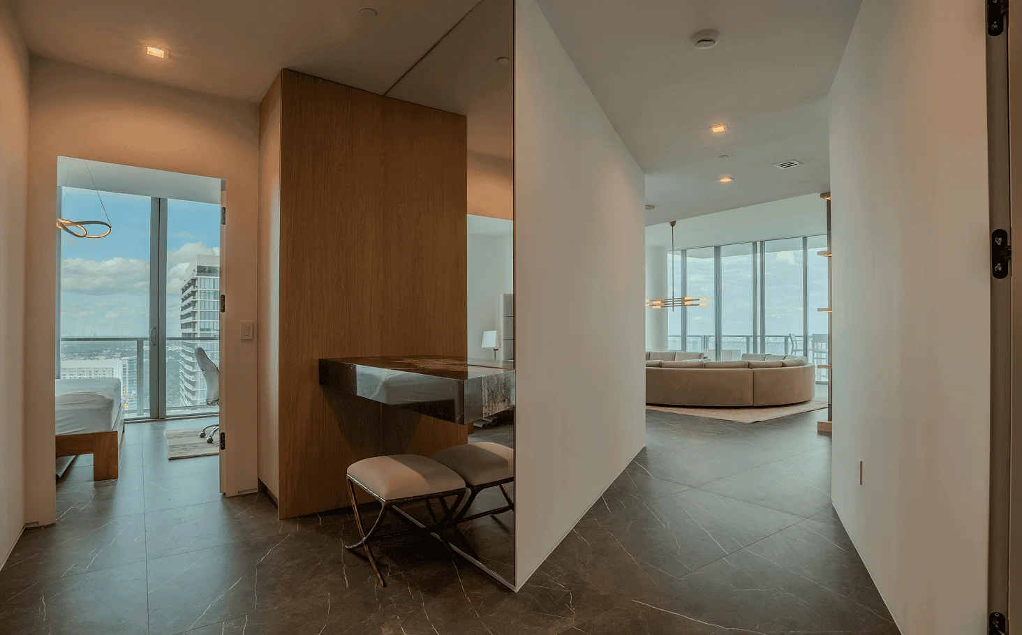 Sophisticated entrance and elevator lobby featuring full wall paneling, custom tall wood door, and luxurious marble flooring