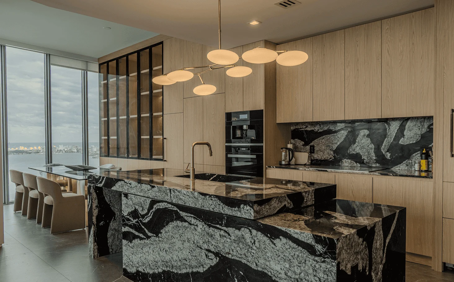 Open-concept living room and kitchen with natural stone dry bar, water-vapor fireplace, sophisticated LED lighting, and custom island