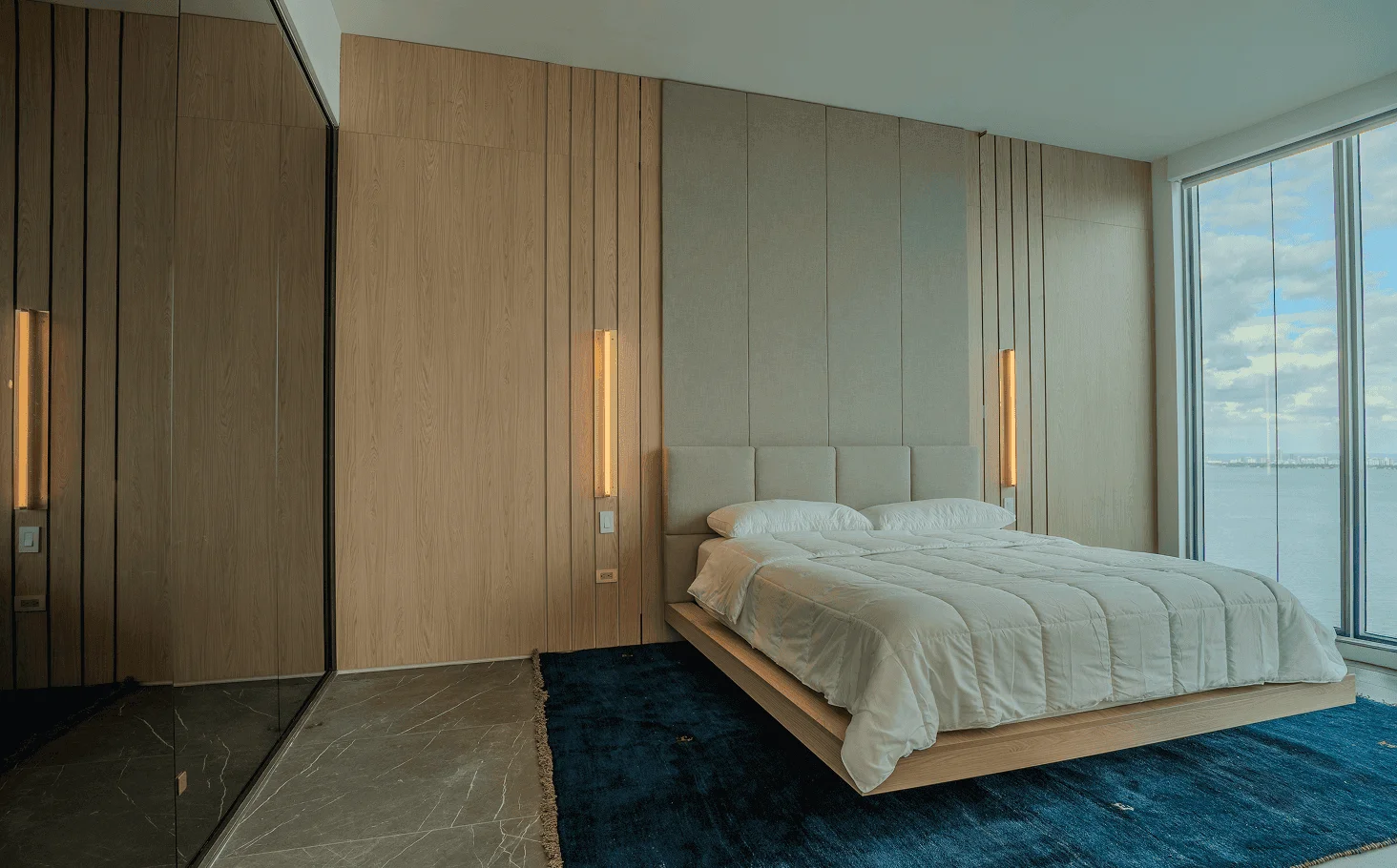 Spa-like master bathroom with glass wall, custom marble sinks, large porcelain slabs, Venetian plaster, and smart toilet