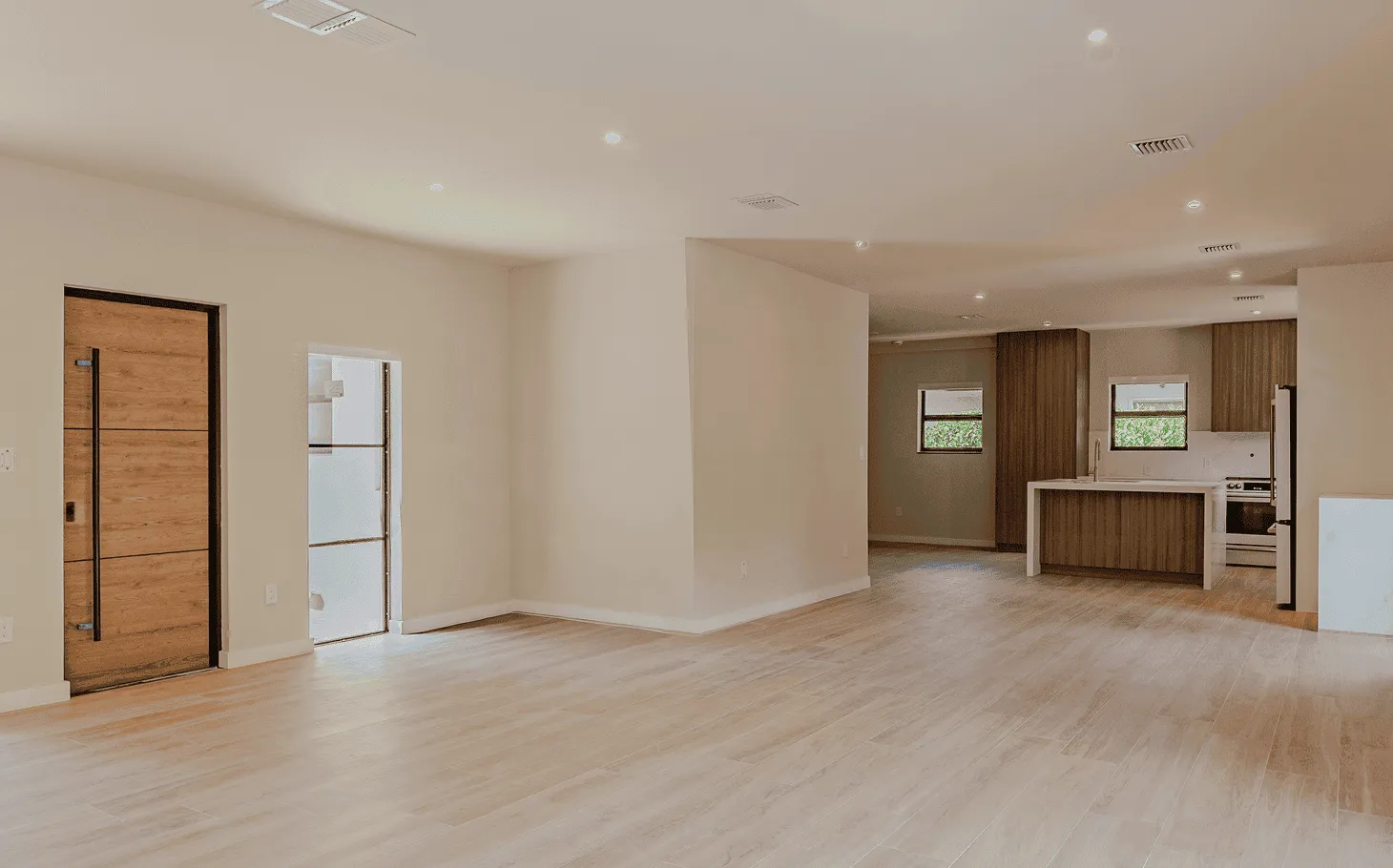 Contemporary kitchen in the Axis Brickell condo featuring marble countertops, oak millwork, and concealed appliances for a seamless modern look.