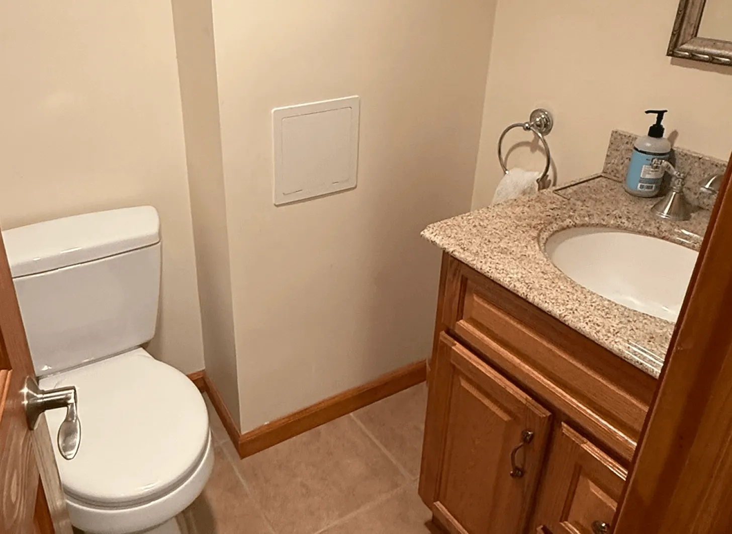 Maplewood basement powder room before renovation showing outdated fixtures and worn finishes