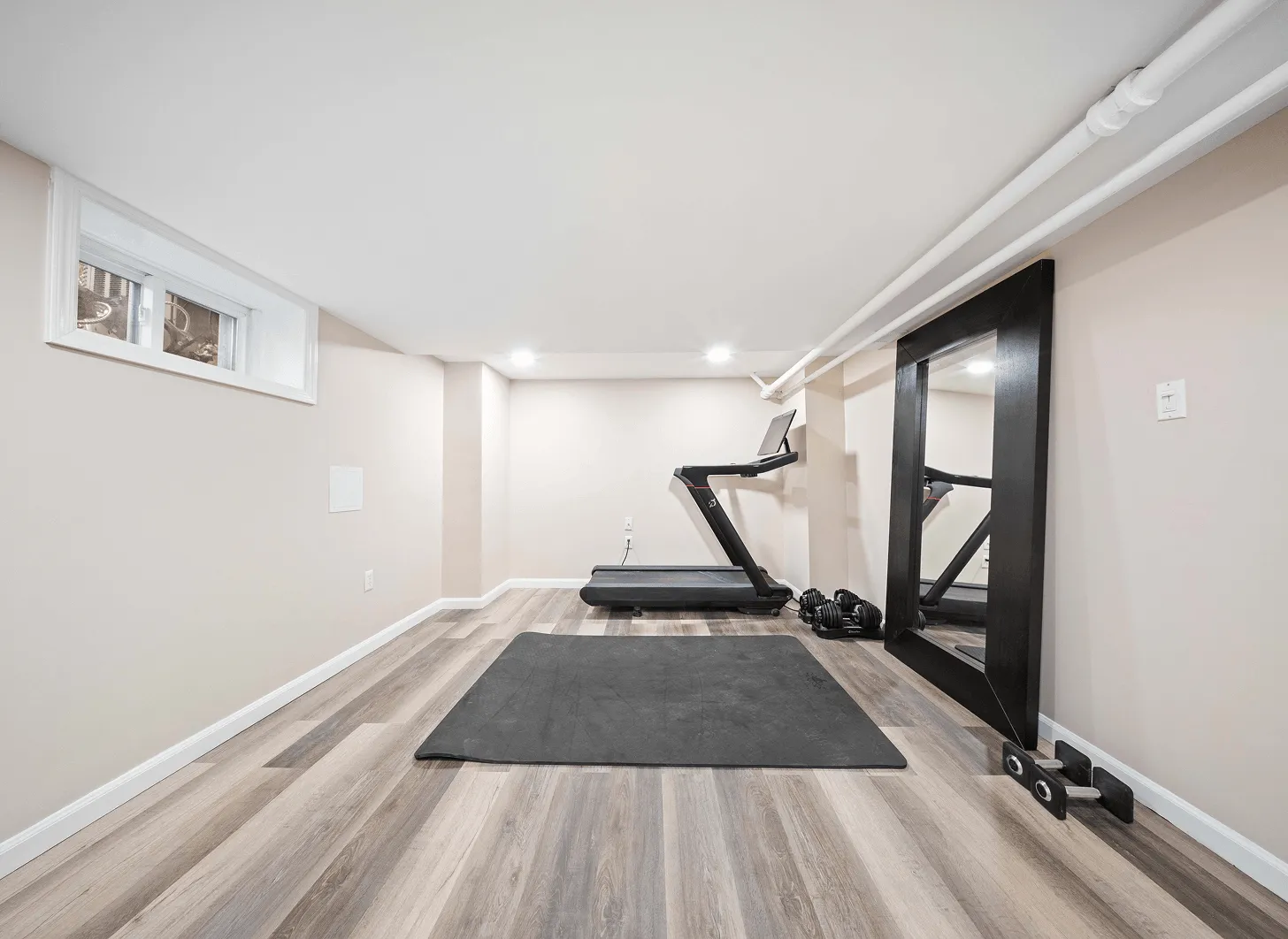 Renovated Maplewood basement gym area with updated flooring, lighting, and modern finishes