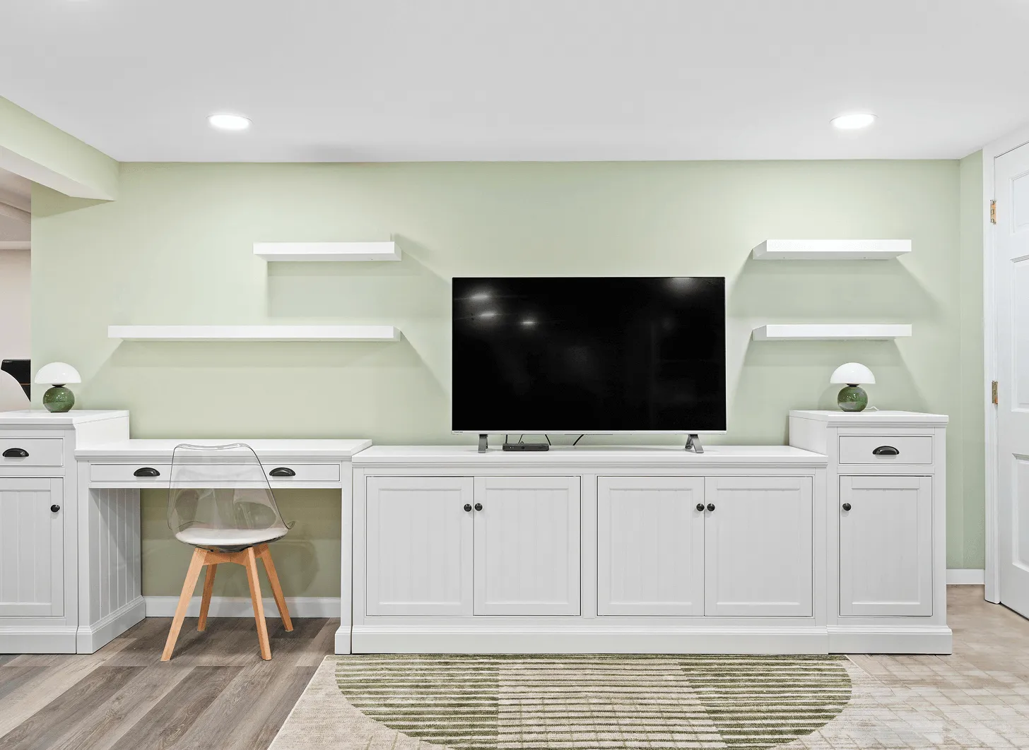Renovated Maplewood basement living space with built-in entertainment wall and wood flooring