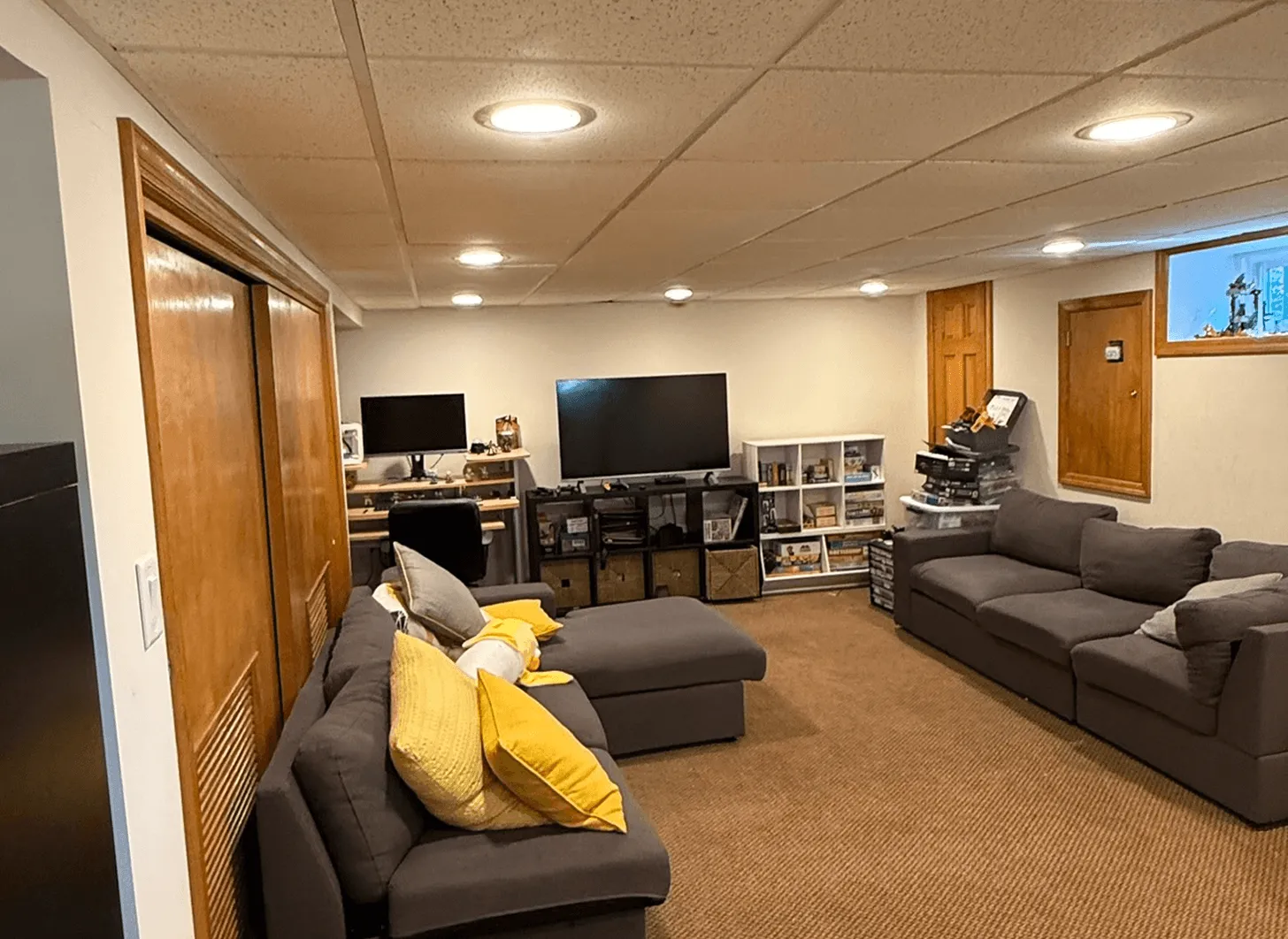 Maplewood basement living area before renovation showing unfinished walls and dated finishes