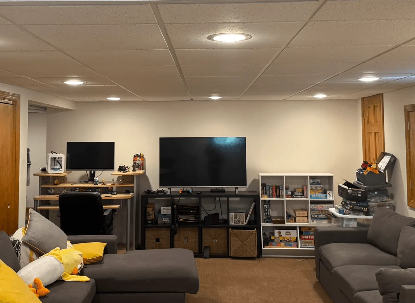 Maplewood basement living area before renovation with exposed ceiling and unfinished surfaces