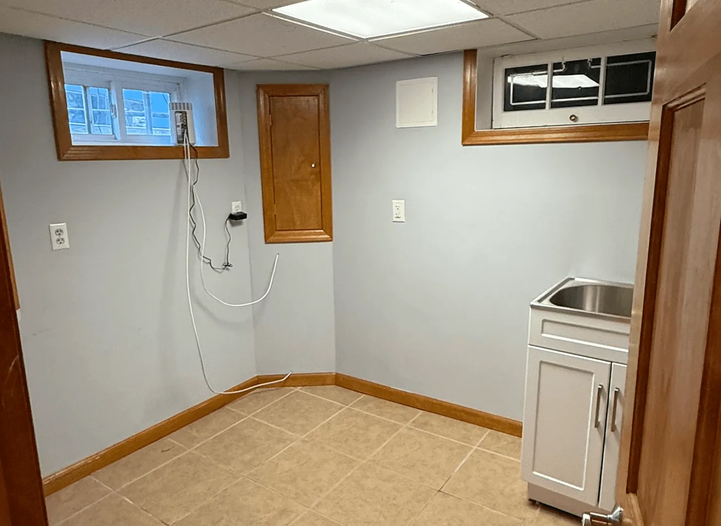 Maplewood basement office area before renovation with unfinished walls and bare flooring