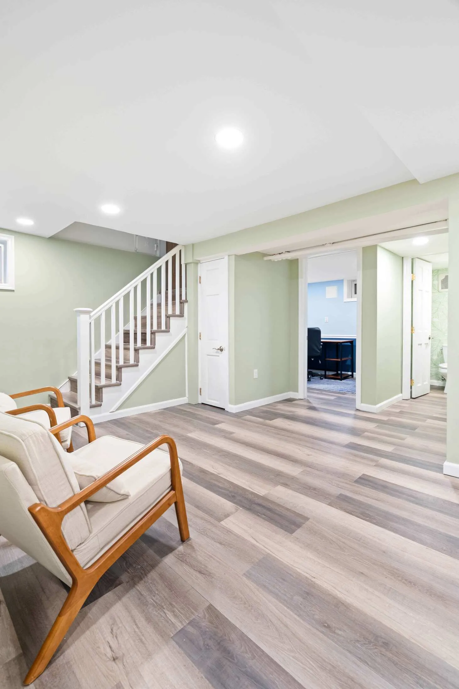 Bright Maplewood basement showing new staircase, seating, and powder room doorway