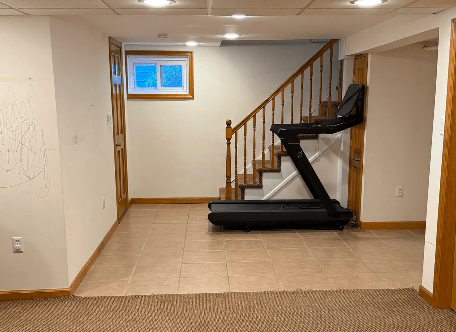 Maplewood basement staircase before renovation showing dated treads and unfinished surroundings