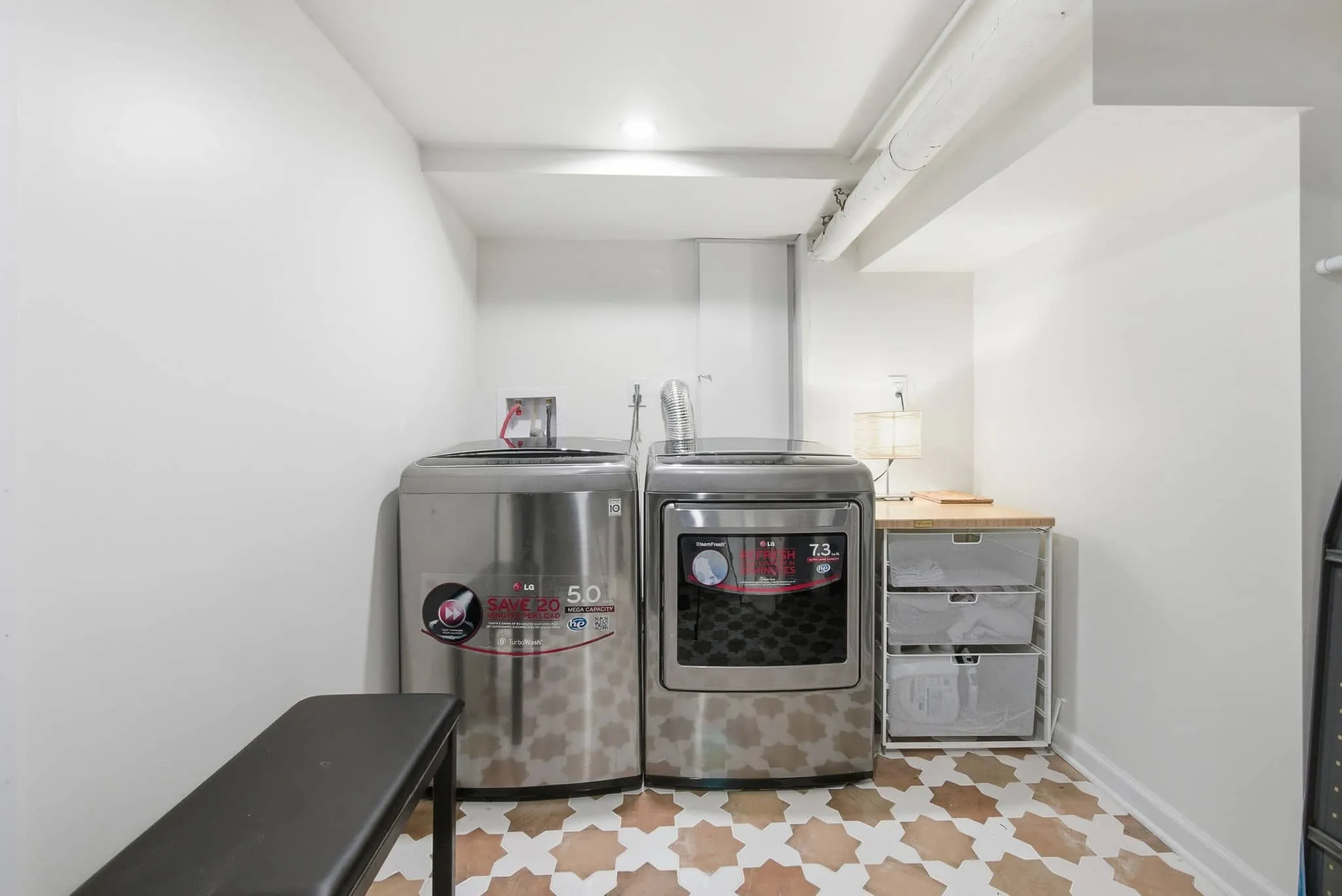 Renovated West Orange basement laundry area with updated cabinetry, flooring, and modern fixtures