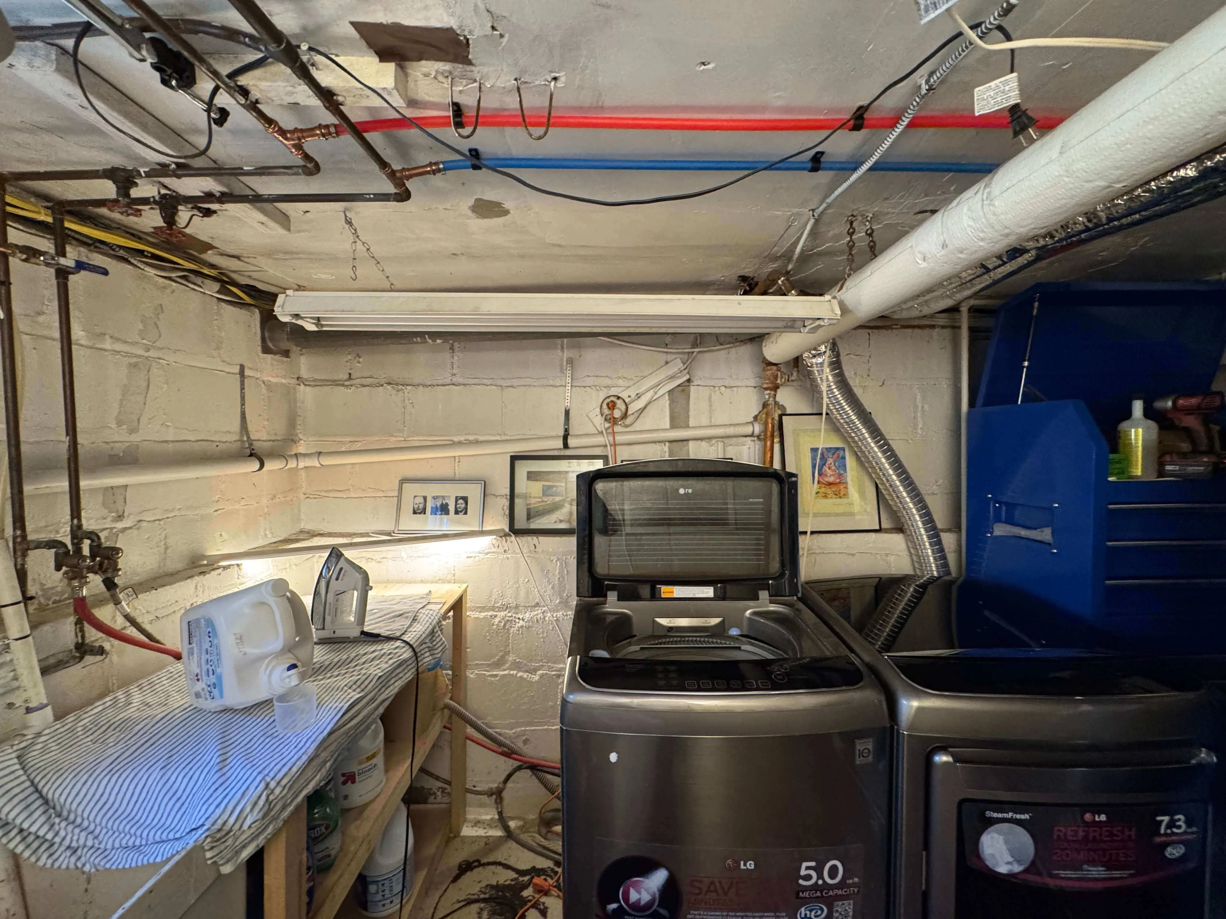 West Orange basement laundry area before renovation showing dated appliances and unfinished surfaces