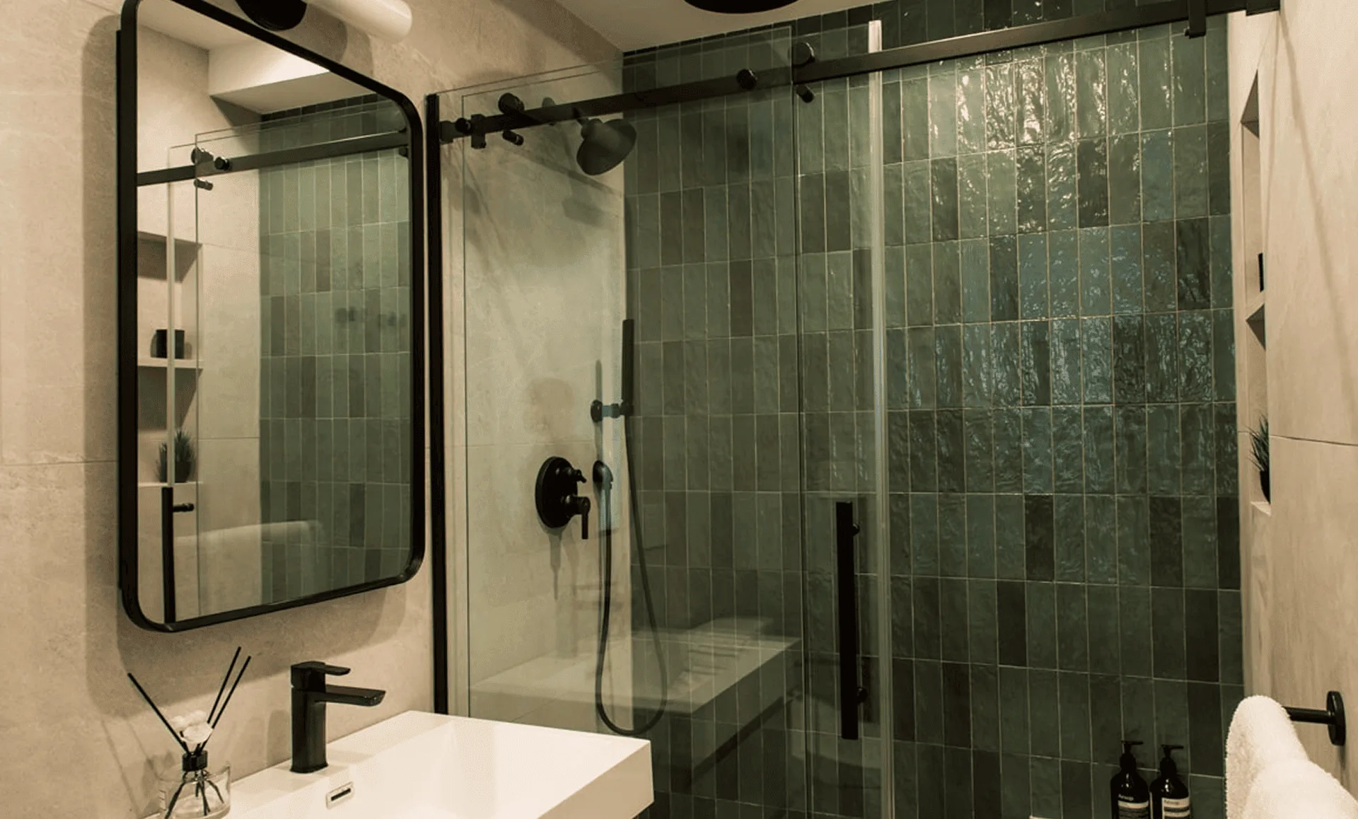 Bathroom with green vertically stacked shower tiles, black framed mirror, black fixtures, part of a full apartment renovation at 80 East End Avenue in Yorkville NYC