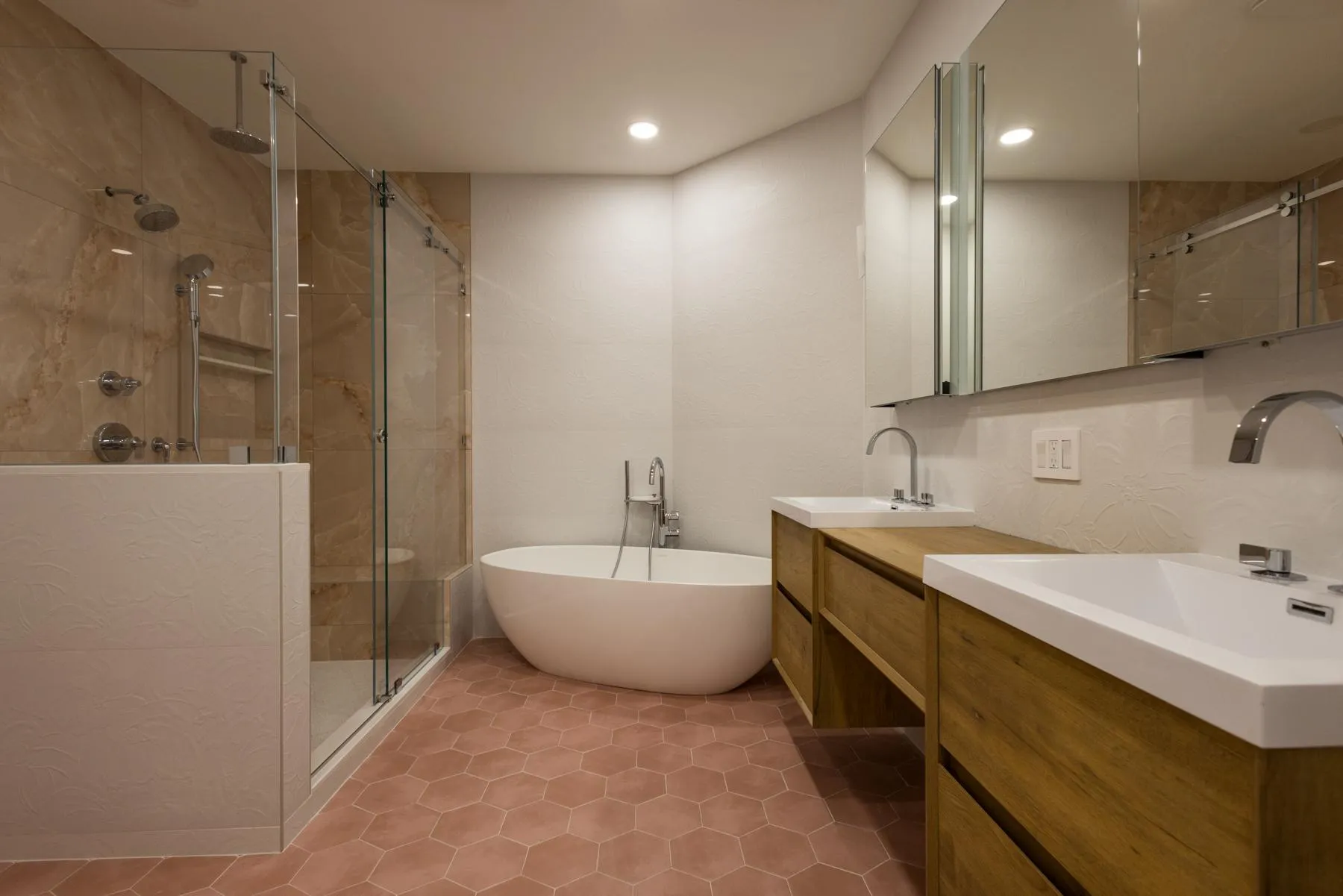 Renovated primary bathroom in Rye Brook home with freestanding tub, enlarged shower with built-in bench, and light-integrated medicine cabinets
