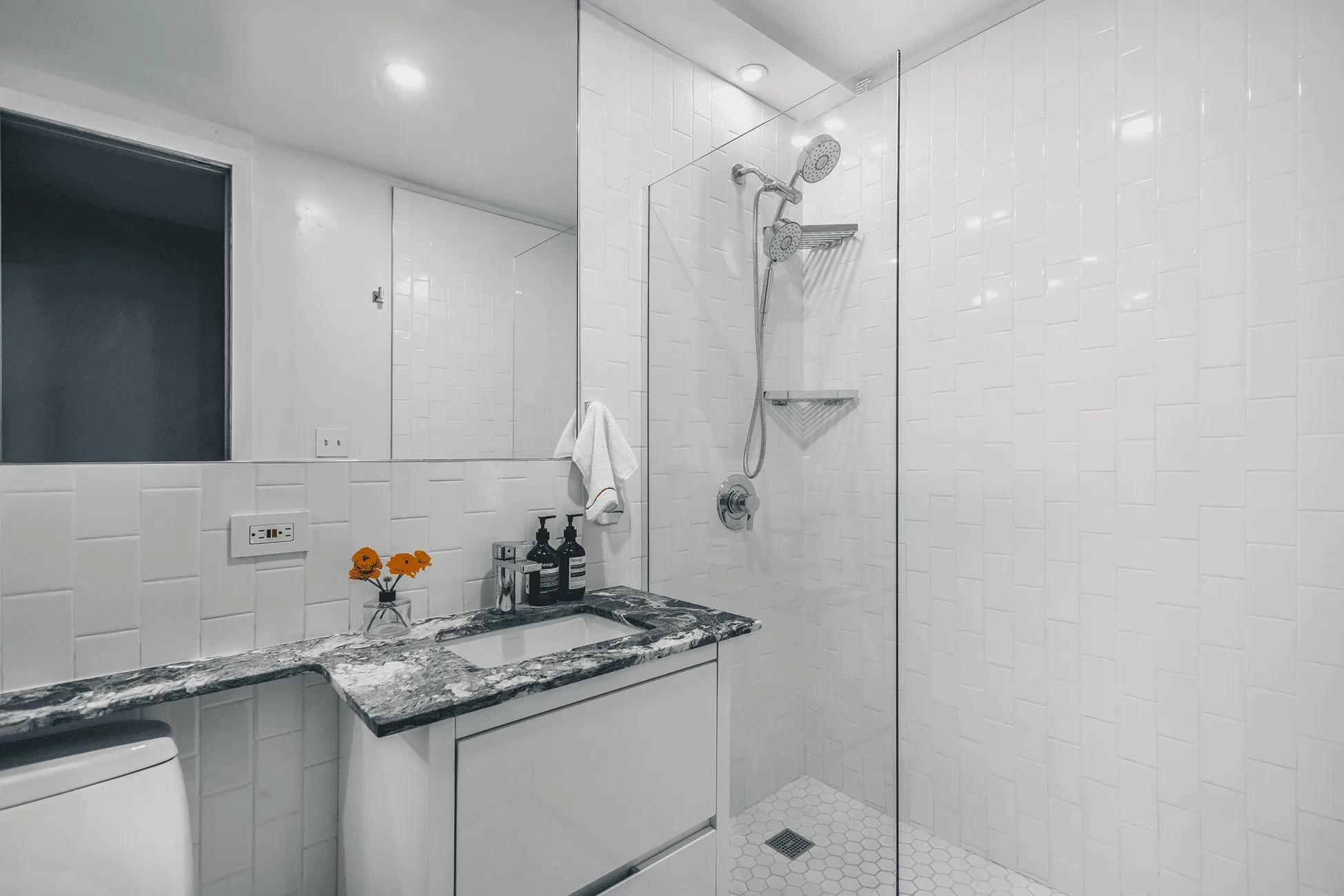 Modern bathroom renovation after with deep blue walls and Italian Verde Alpi marble countertop in Jersey City apartment