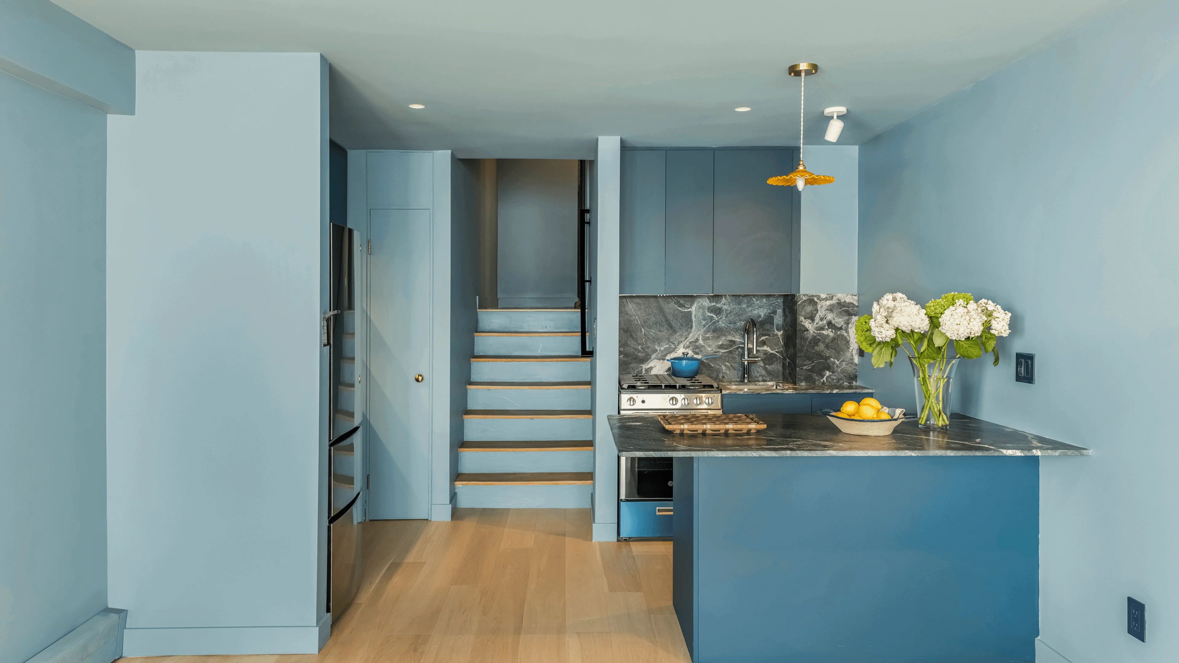 Jersey City apartment renovation by Chapter featuring modern kitchen with Italian Verde Alpi stone and custom deep blue design
