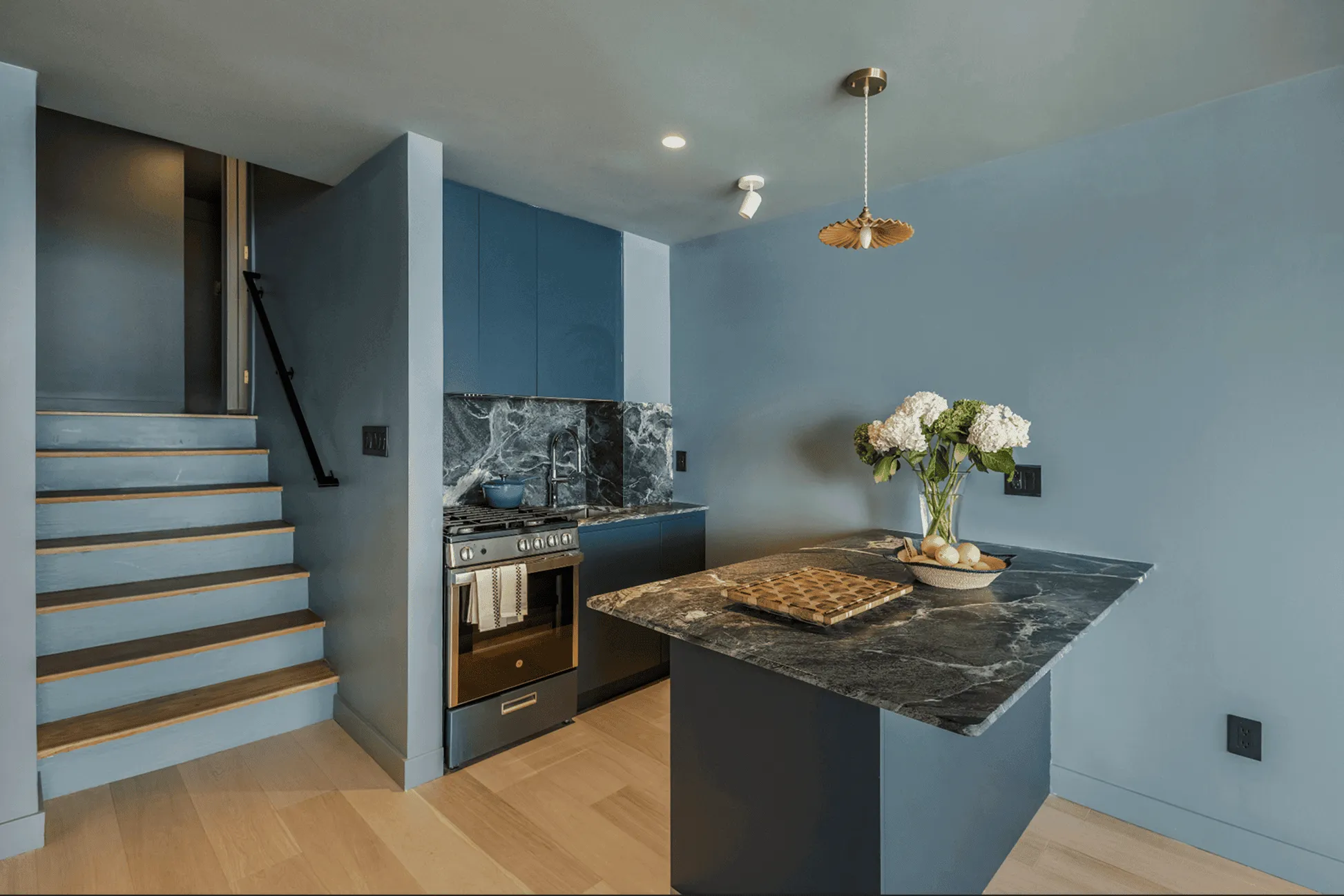 Jersey City kitchen renovation after showing blue custom cabinetry with integrated lighting and modern appliances