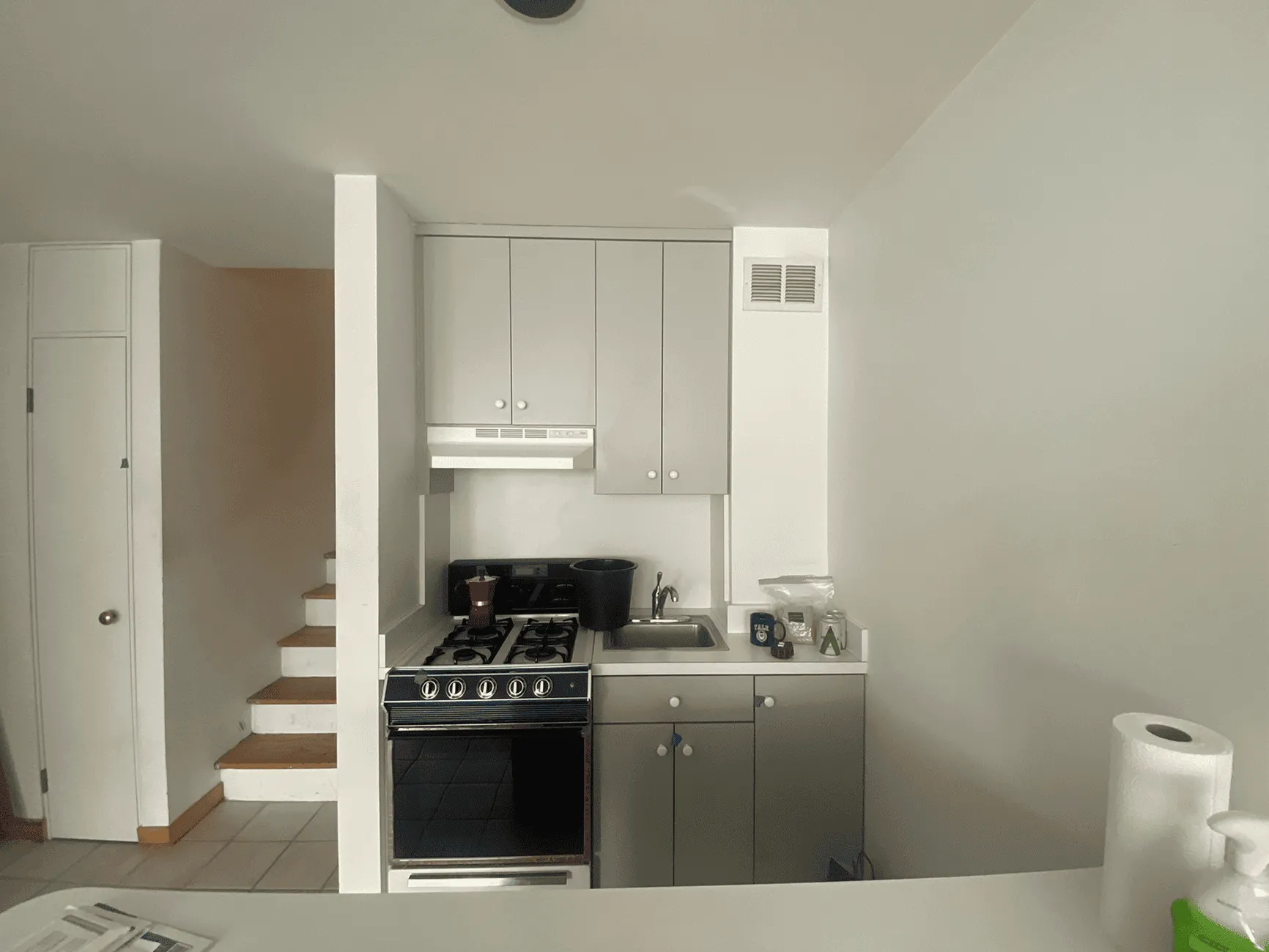 Kitchen before renovation in Jersey City apartment with outdated cabinets and layout