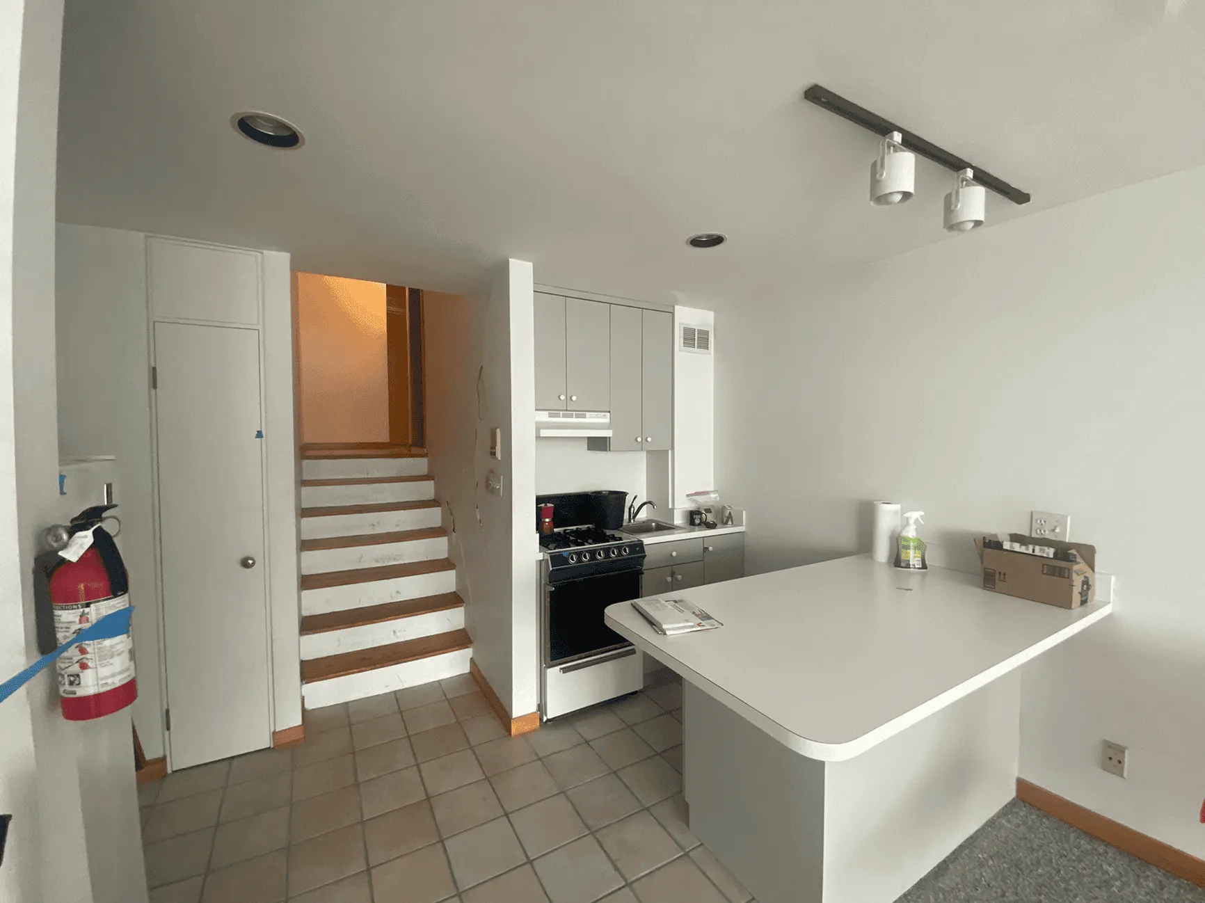 Original kitchen before renovation showing old white cabinets and basic finishes