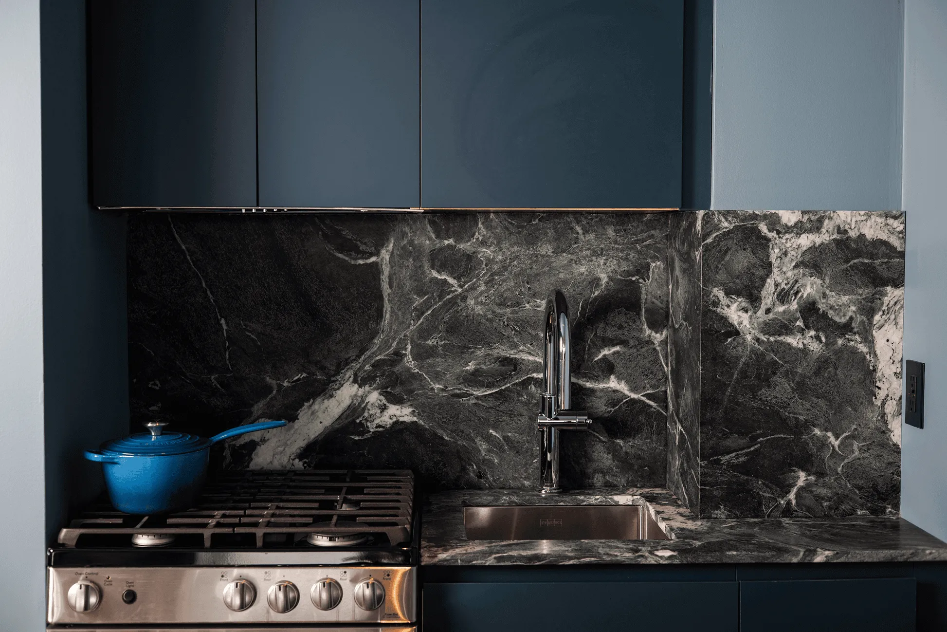 Close-up of renovated Jersey City kitchen featuring Italian Verde Alpi stone backsplash and countertop detail