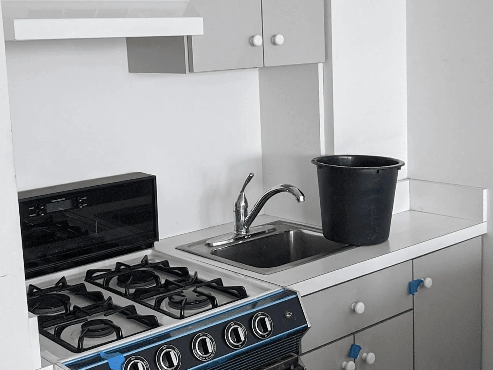 Kitchen countertop area before renovation with basic white tile backsplash