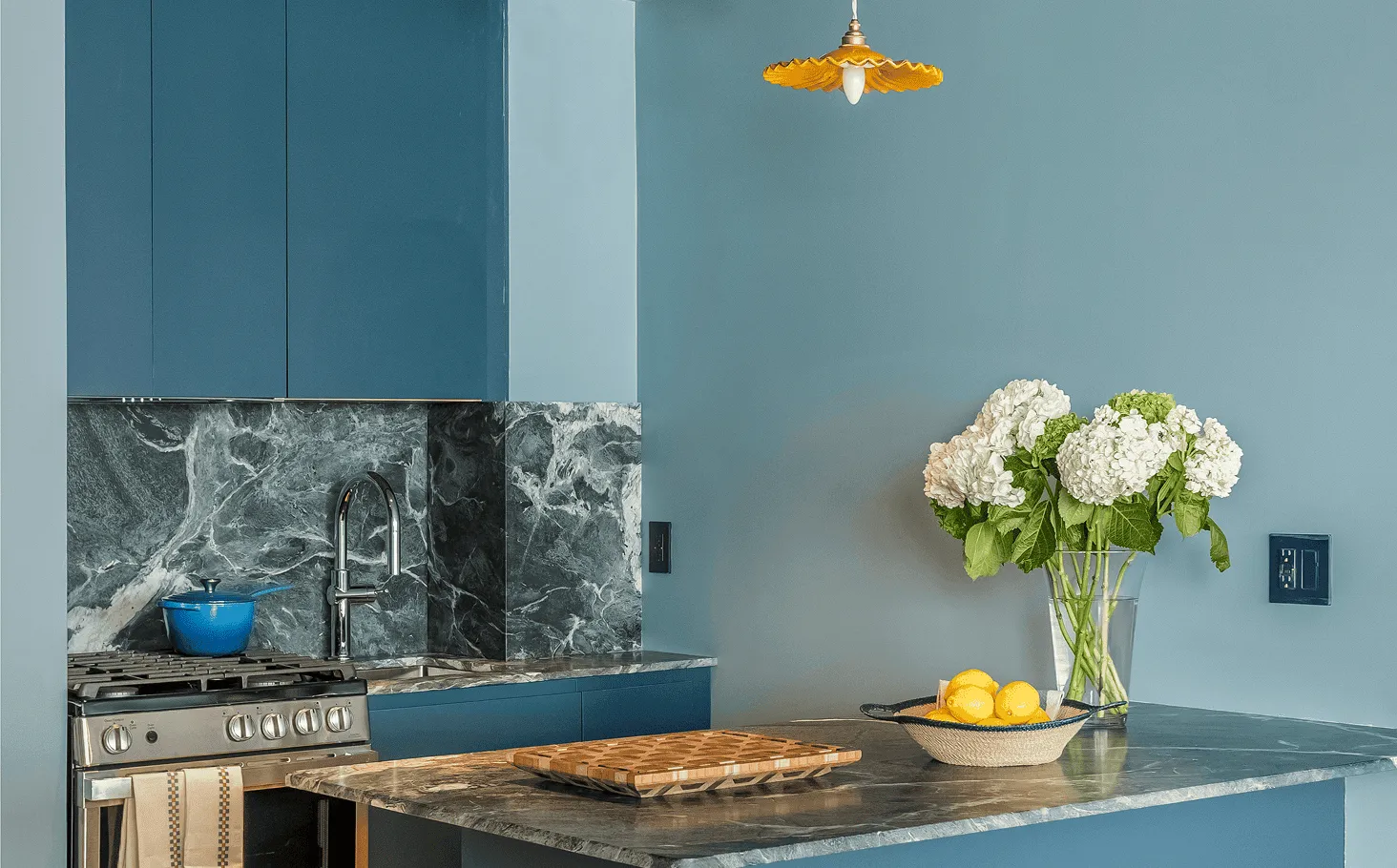 Modern Jersey City kitchen renovation with Italian Verde Alpi stone countertop and custom deep blue cabinetry