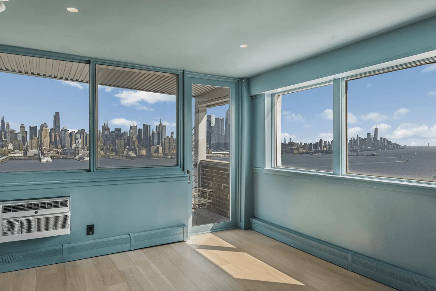 Renovated Jersey City apartment living area after with custom deep blue paint and white oak hardwood floors