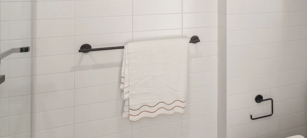 Matte black towel bar and toilet paper holder on white subway tile