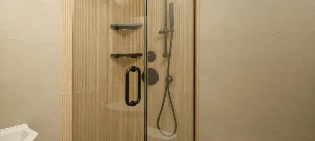 Neutral fluted shower wall tile with matte black fixtures in the renovated bathroom