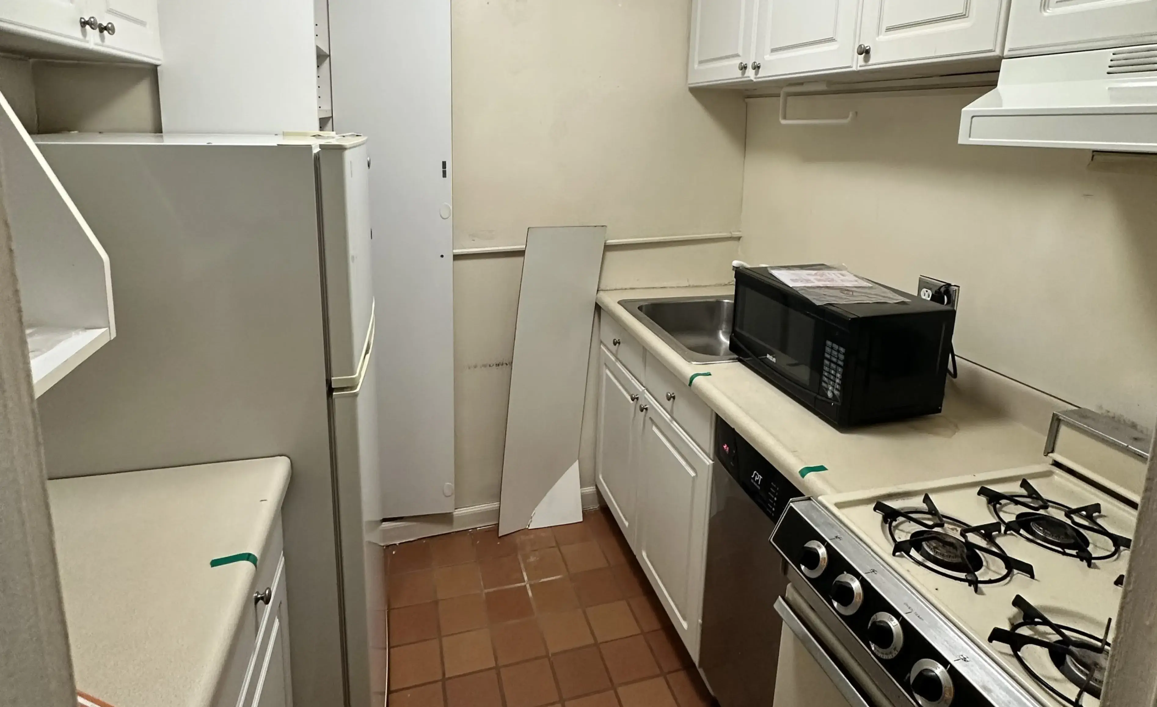 Before renovation view of Manhattan studio apartment showing outdated kitchen and living space