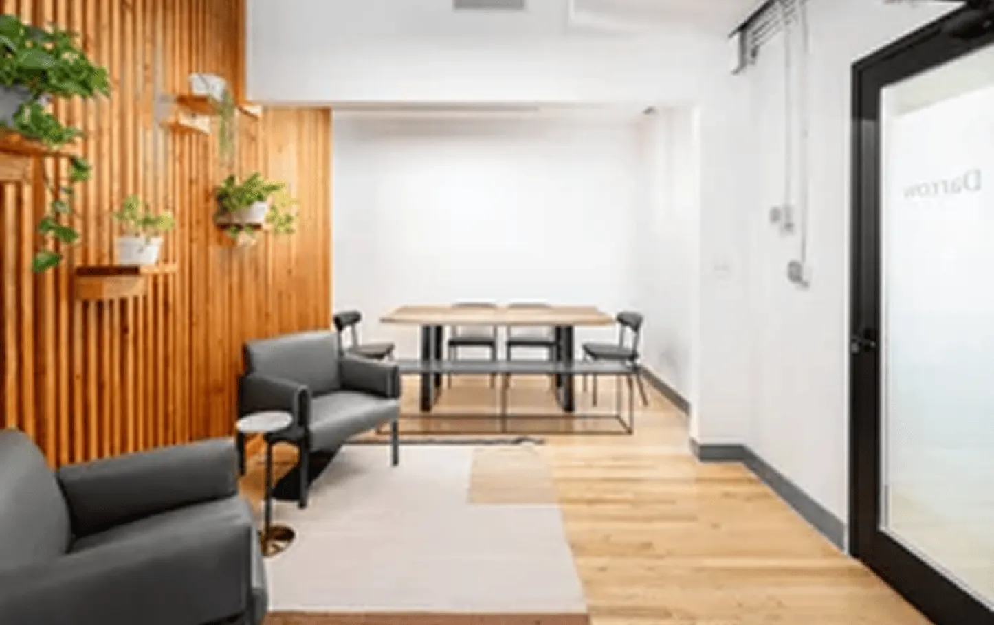 Open kitchen and living area in a renovated Axis Brickell condo, featuring marble countertops, wood cabinetry, and floor-to-ceiling windows overlooking the Miami skyline.