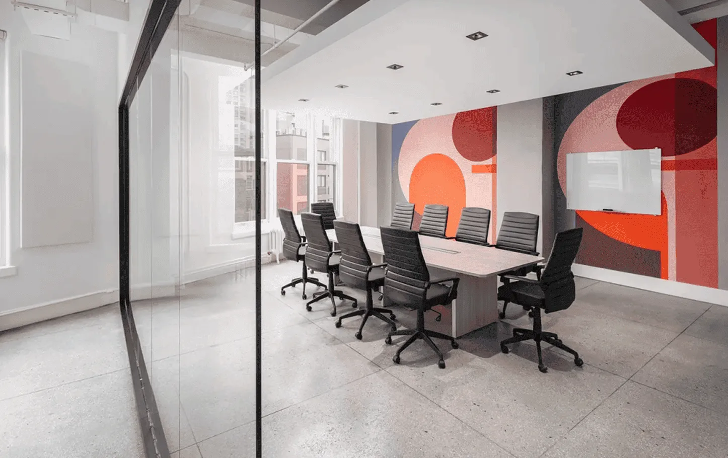 Modern conference room in NYC tech headquarters with glass enclosures and brand-inspired feature wall