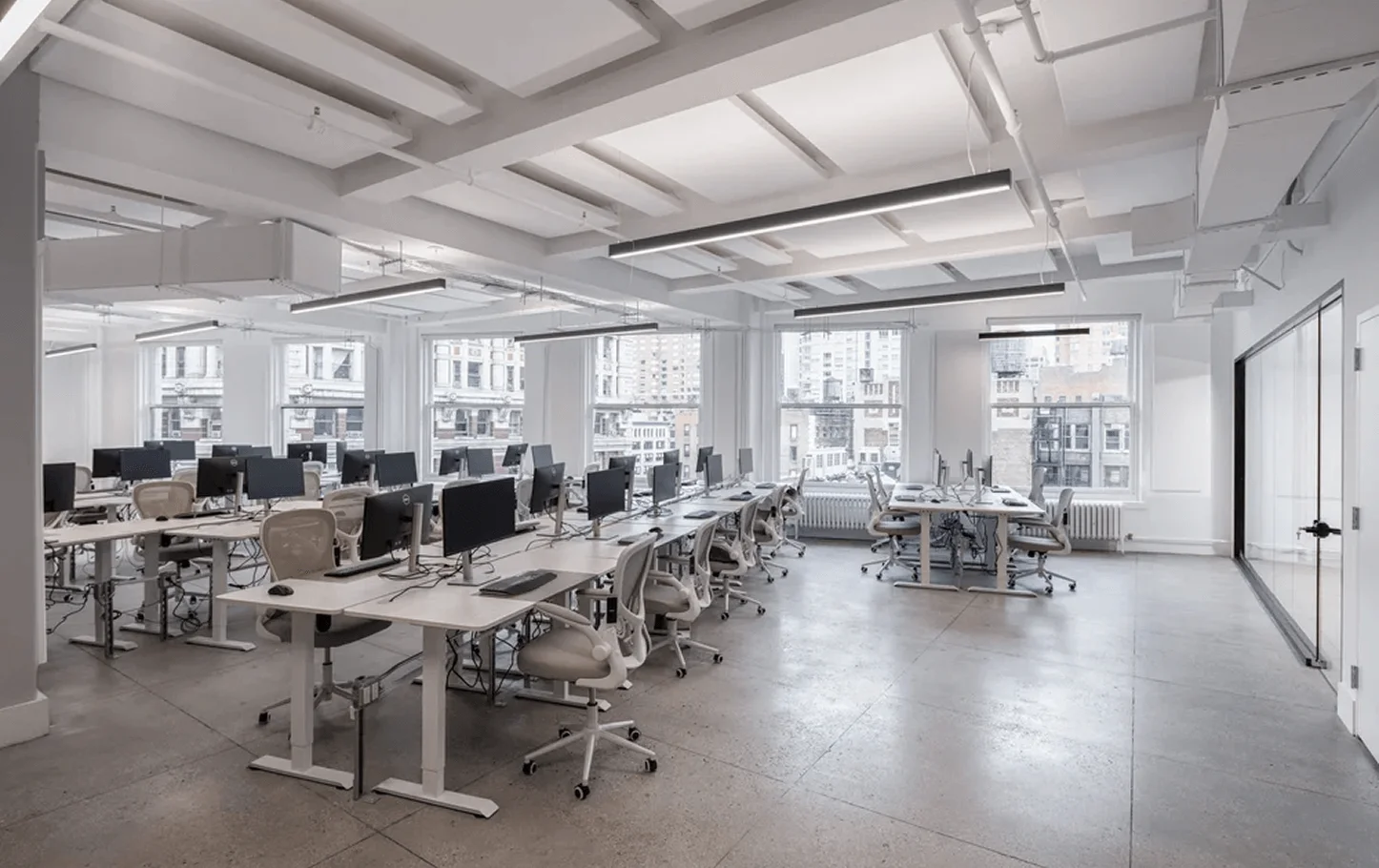 Open workspace design in NYC tech headquarters with integrated electrical infrastructure and LED lighting