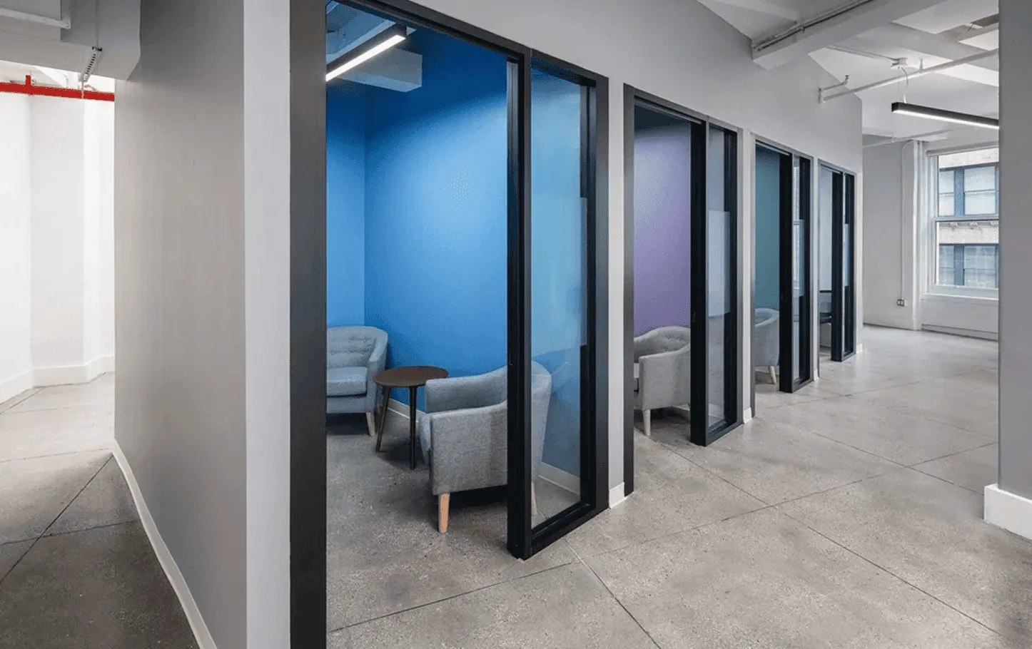 Focus rooms and private offices in NYC tech headquarters featuring glass-front design and brand colors