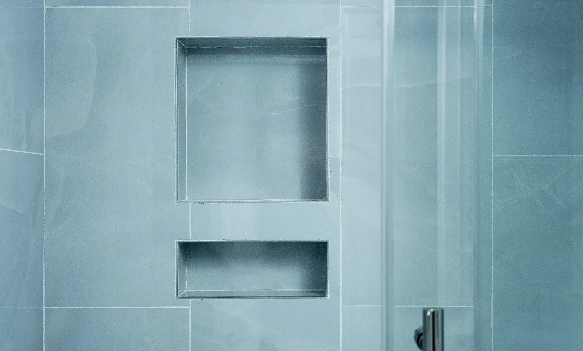 UES apartment with glass subway tile accent wall in guest bathroom