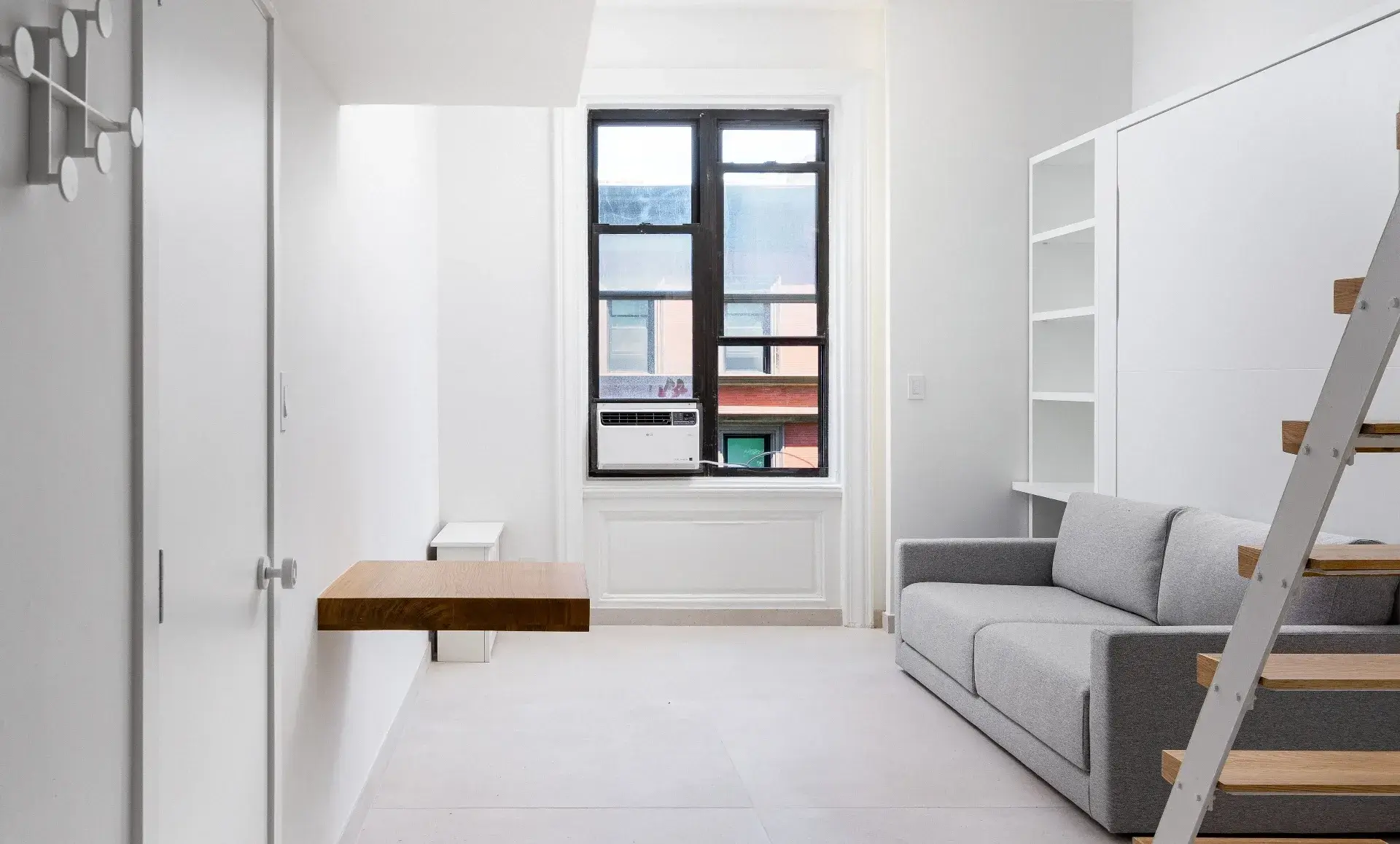 UWS studio apartment after renovation with custom white millwork and built-in desk